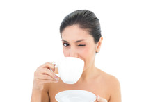 Pretty Brunette Holding A Cup And Saucer And Taking A Sip While