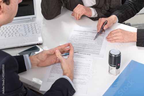 Fotografía hands of three people, signing documents