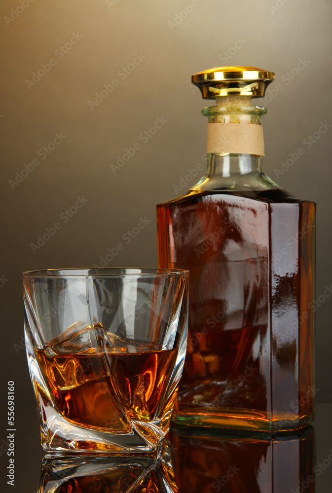 Glass of whiskey with bottle, on dark background