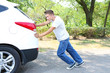 © Africa Studio - Young man pushing broken down car