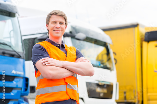 Fotografia  Spediteur vor Lastwagen und LKW auf Depot