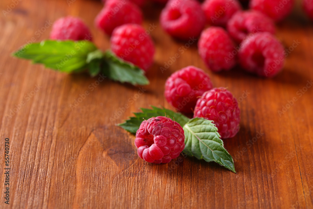 Ripe sweet raspberries on wooden background