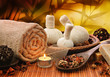 Massage background with rolled towel, spa balls and candlelight