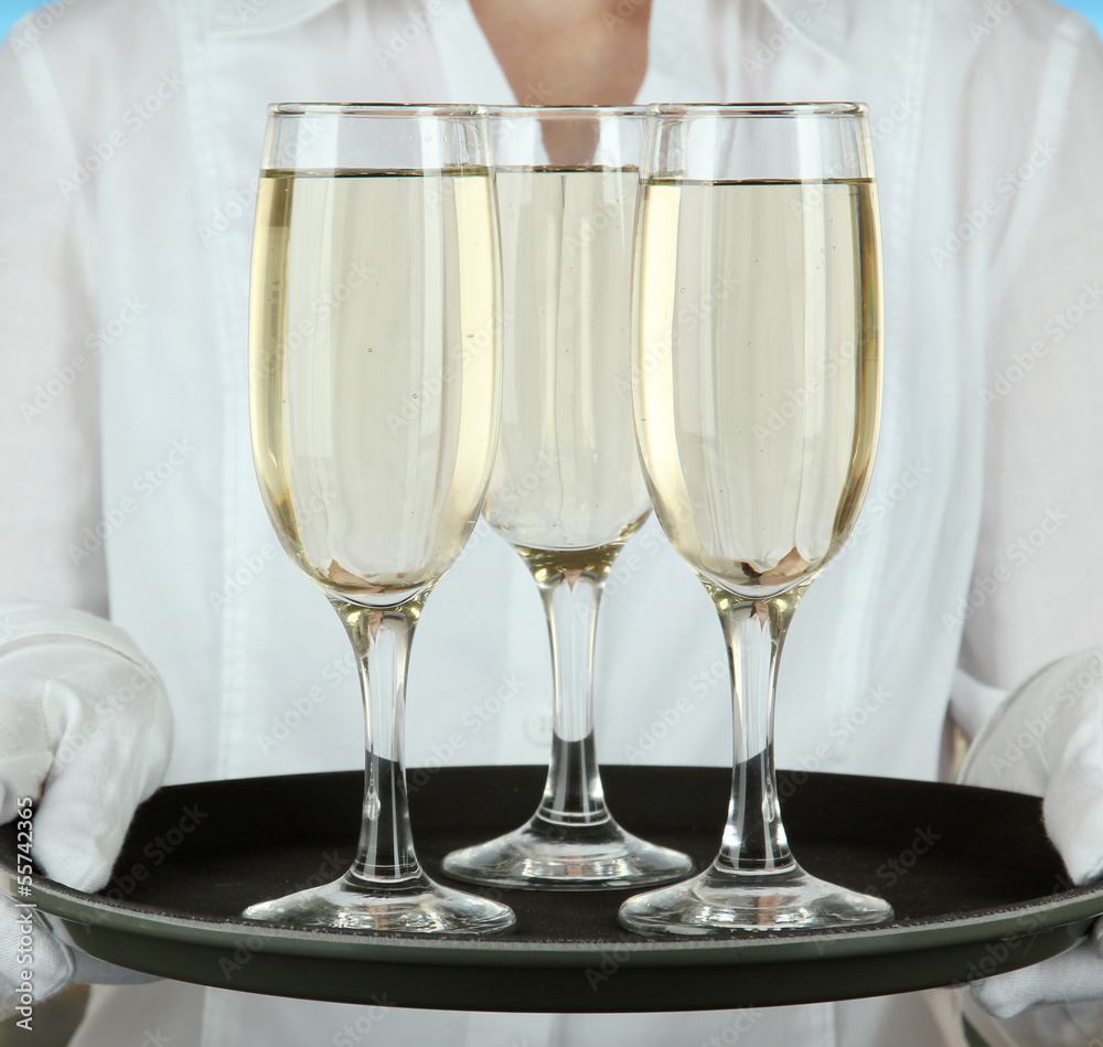Waitresses holding tray with glasses of champagne