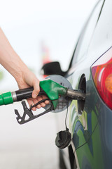 man pumping gasoline fuel in car at gas station