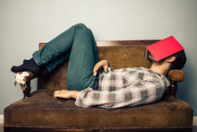 Man Sleeping On Old Sofa With Book Covering His Face