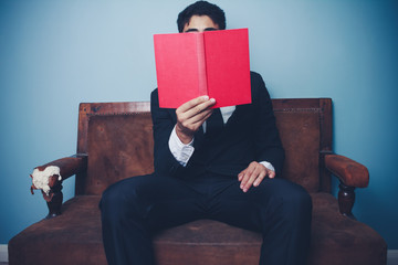 Businessman on sofa is reading