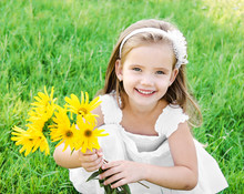 Cute Little Girl On The Meadow With Flower
