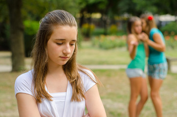 Wall Mural - Two teenage girls making fun of the third