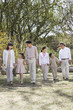 © xixinxing - Happy smiling family holding hands and going for a walk in the springtime, standing in a row