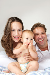 Happy caucasian family smiling with baby