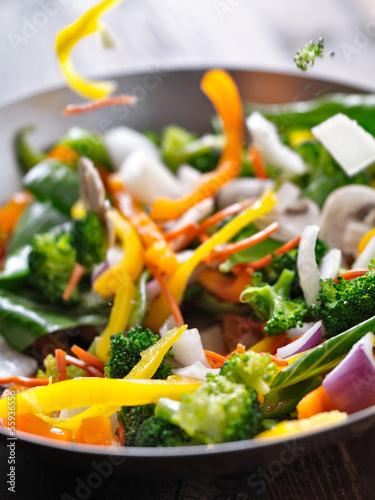 Fotomural vegetables falling into a stir fry wok.