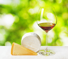 Canvas Print - Cheese and glass of wine on nature background