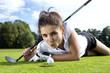 Pretty girl playing golf on grass