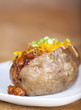 Loaded baked potato with chili and cheese on a plate
