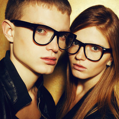 Portrait of gorgeous red-haired fashion twins in black glasses