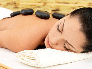 Stone massage for woman at  spa salon.