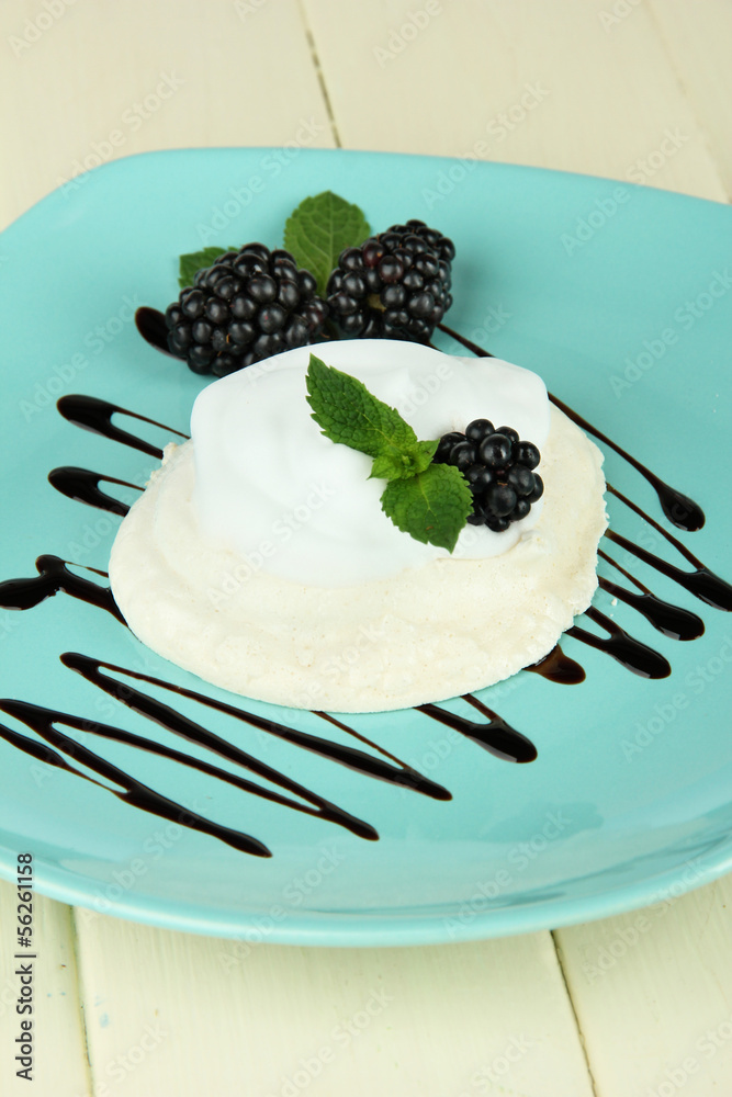Tasty meringue cake with berries on wooden table