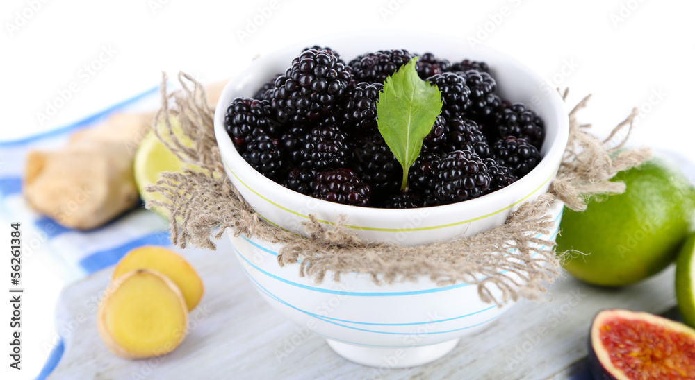 Blackberry in small bowl on board on napkin isolated on white