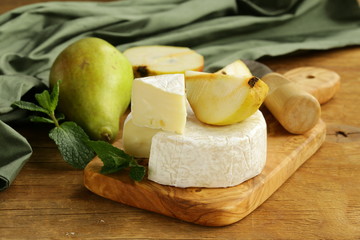 Poster - soft brie cheese (camembert) with pears on a wooden board