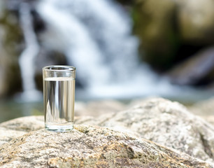 Canvas Print - Glass of water by waterfall