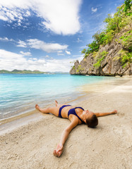 Poster - Young beautiful woman is relaxing on sand by the sea