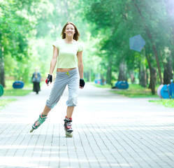 Wall Mural - Roller skating sporty girl in park rollerblading on inline skate