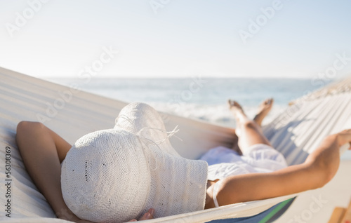 Valokuva Peaceful woman in sunhat relaxing on hammock