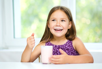 Wall Mural - Cute little girl with a glass of milk