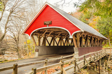 Red Wooden Covered Bridge In Autumn And Cloudy Sky