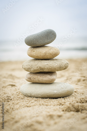 Nowoczesny obraz na płótnie Stones piled up on a sand beach