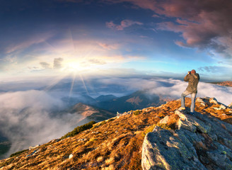 Sticker - Photographer takes a sunset in the mountains