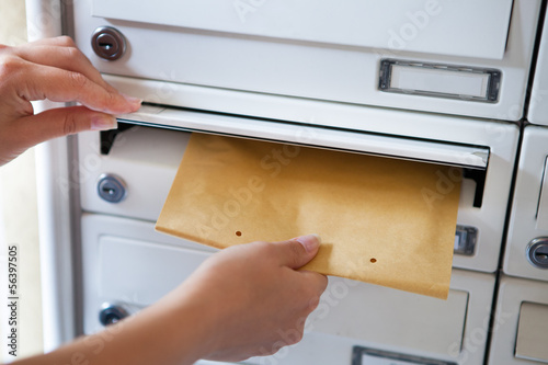 Fotomural Woman putting envelope in mailbox