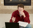 Mature man drinking water while working on assignments at home