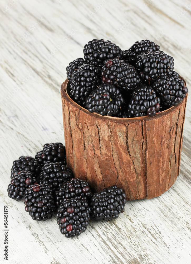 Sweet blackberries in wooden basket on table close-up