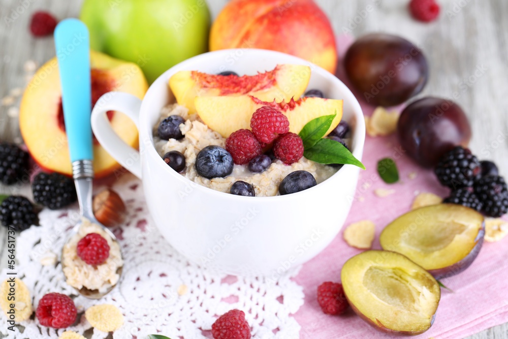 Oatmeal in cup with berries on napkins on wooden table