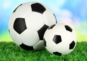 Wall Mural - Soccer balls on green grass on bright background