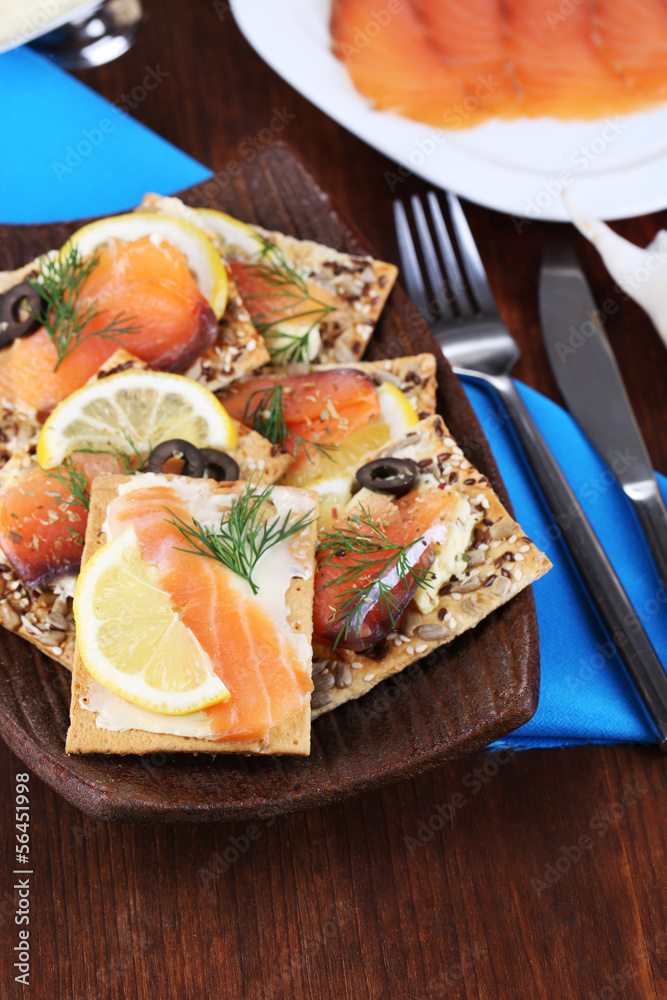 Salmon sandwiches on plate  on wooden table close-up