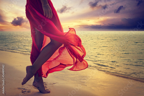 kobieca-sylwetka-w-czerwonej-sukni-nad-brzegiem-morza-na-plazy