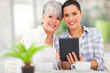 © michaeljung - daughter using tablet pc with her middle aged mother