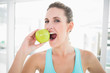 © lightwavemedia - Woman eating green apple
