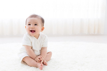 asian baby relaxing on the carpet