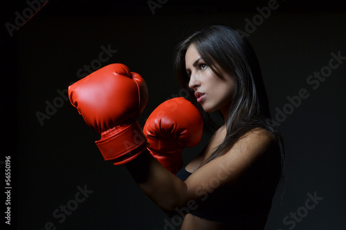 Leinwand Poster beautiful woman with the red boxing gloves,black background