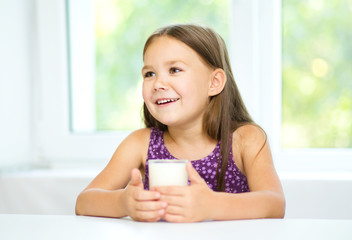 Wall Mural - Cute little girl with a glass of milk