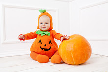 Child In Pumpkin Suit On White Background With Pumpkin