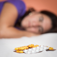 Wall Mural - Depressed or suicidal person looking at a heap of pills