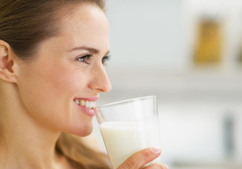 Wall Mural - Happy young housewife drinking milk