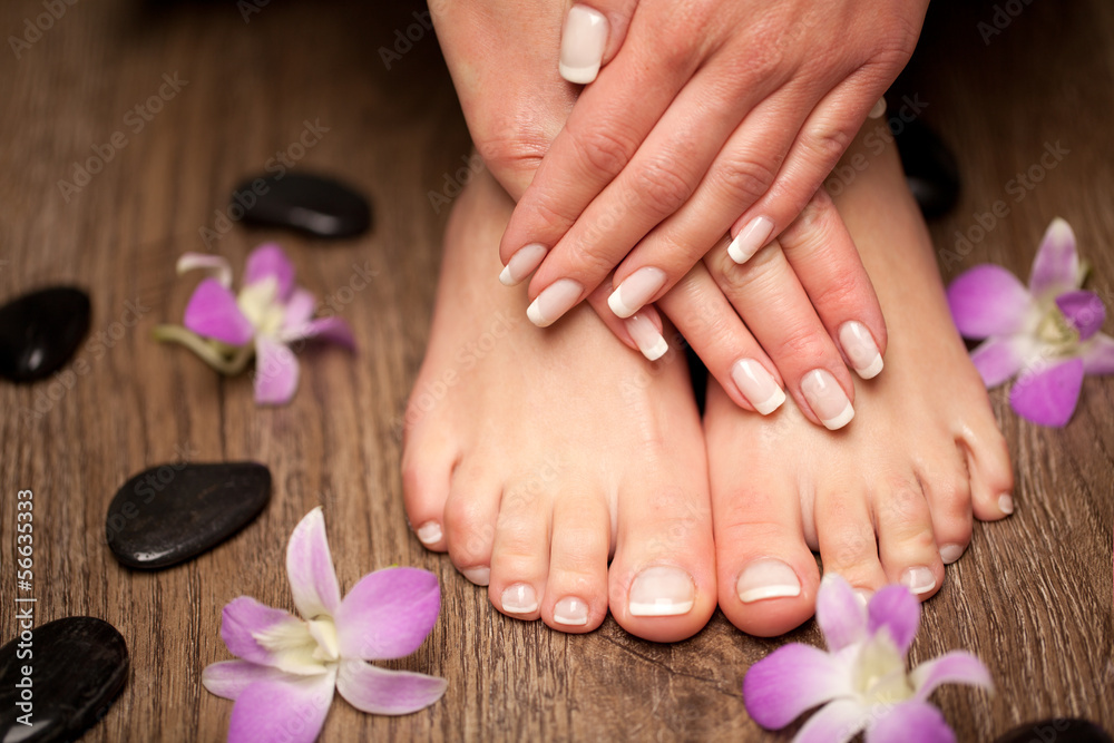 Relaxing pink manicure and pedicure with a orchid flower - obrazy, fototapety, plakaty 