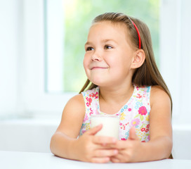 Wall Mural - Cute little girl with a glass of milk