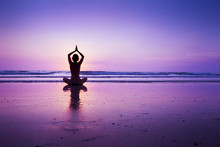 Woman Practicing Yoga On The Beach